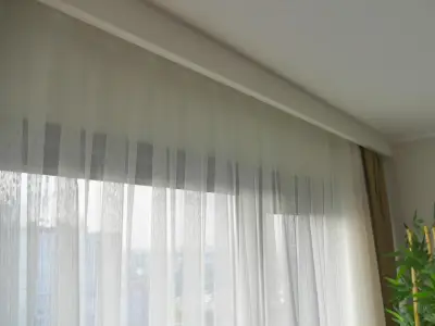 Voile sheer curtains paired with thick drapes in a dual-window setup